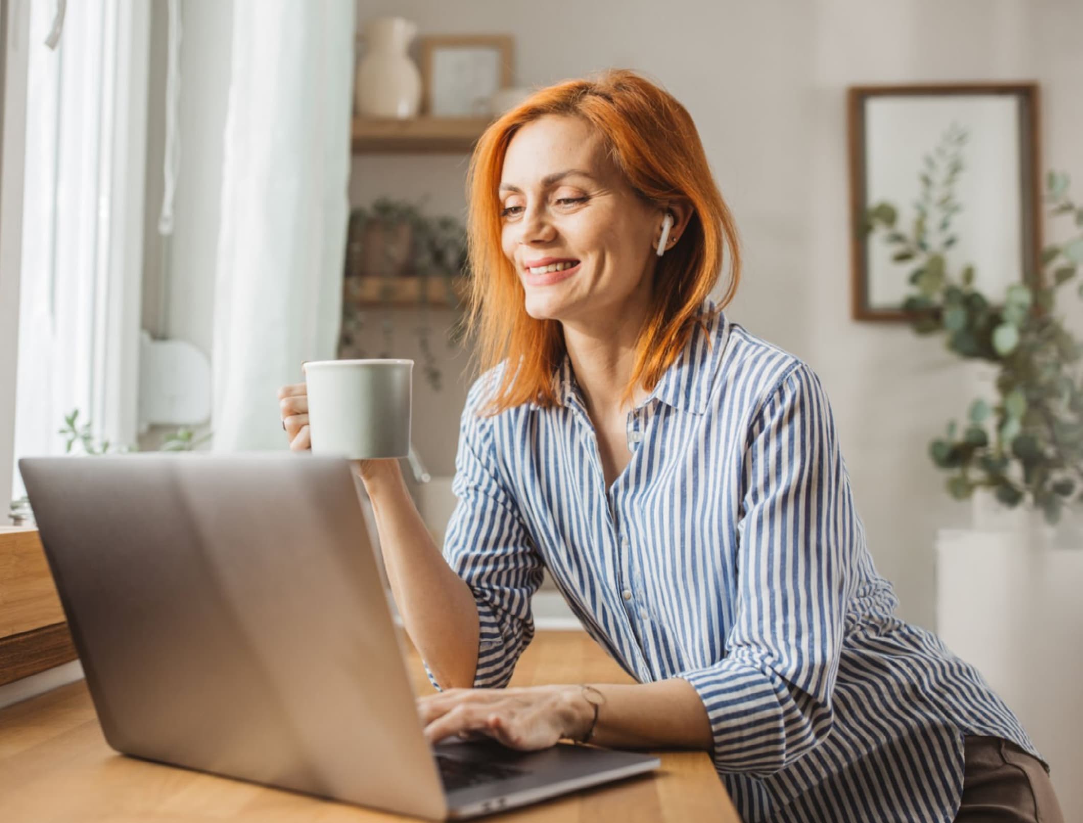 Femme souriante utilisant son ordinateur portable à la maison